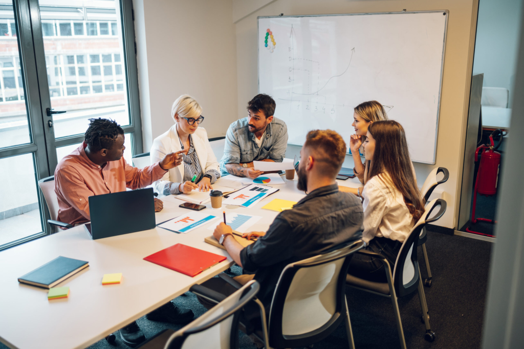 Fun multiracial young creative people in a modern office. Group of diverse business people working together in the creative co-working space. Working with fun people. Copy space.