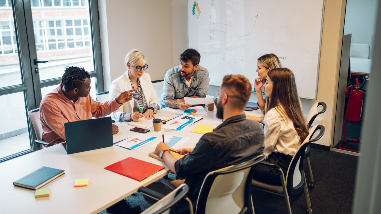 Fun multiracial young creative people in a modern office. Group of diverse business people working together in the creative co-working space. Working with fun people. Copy space.